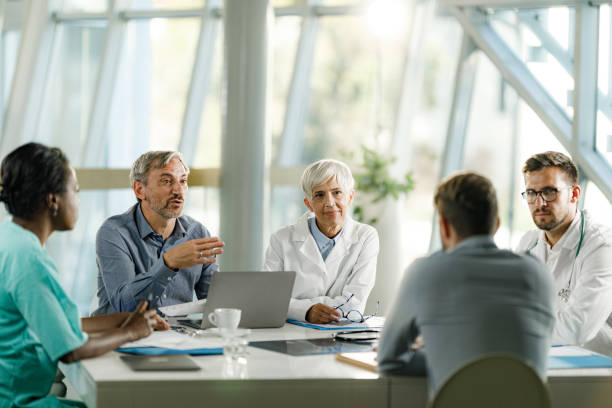 Réunion de professionnels de santé avec un ordinateur portable sur une table